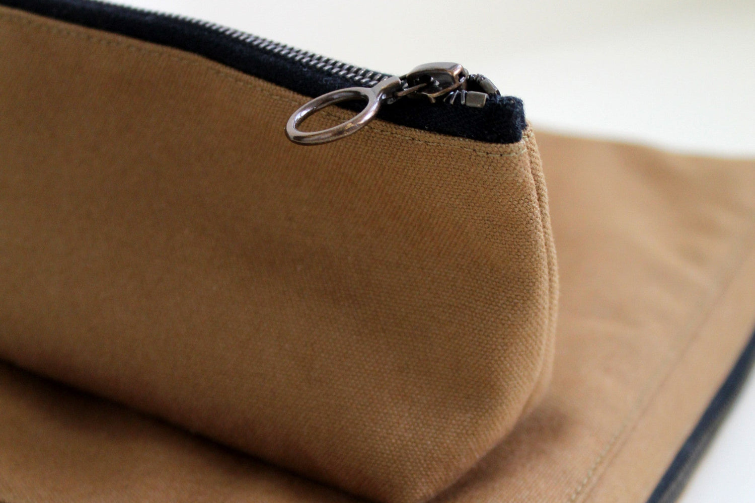 Brown fabric pencil case with zipper on a white background