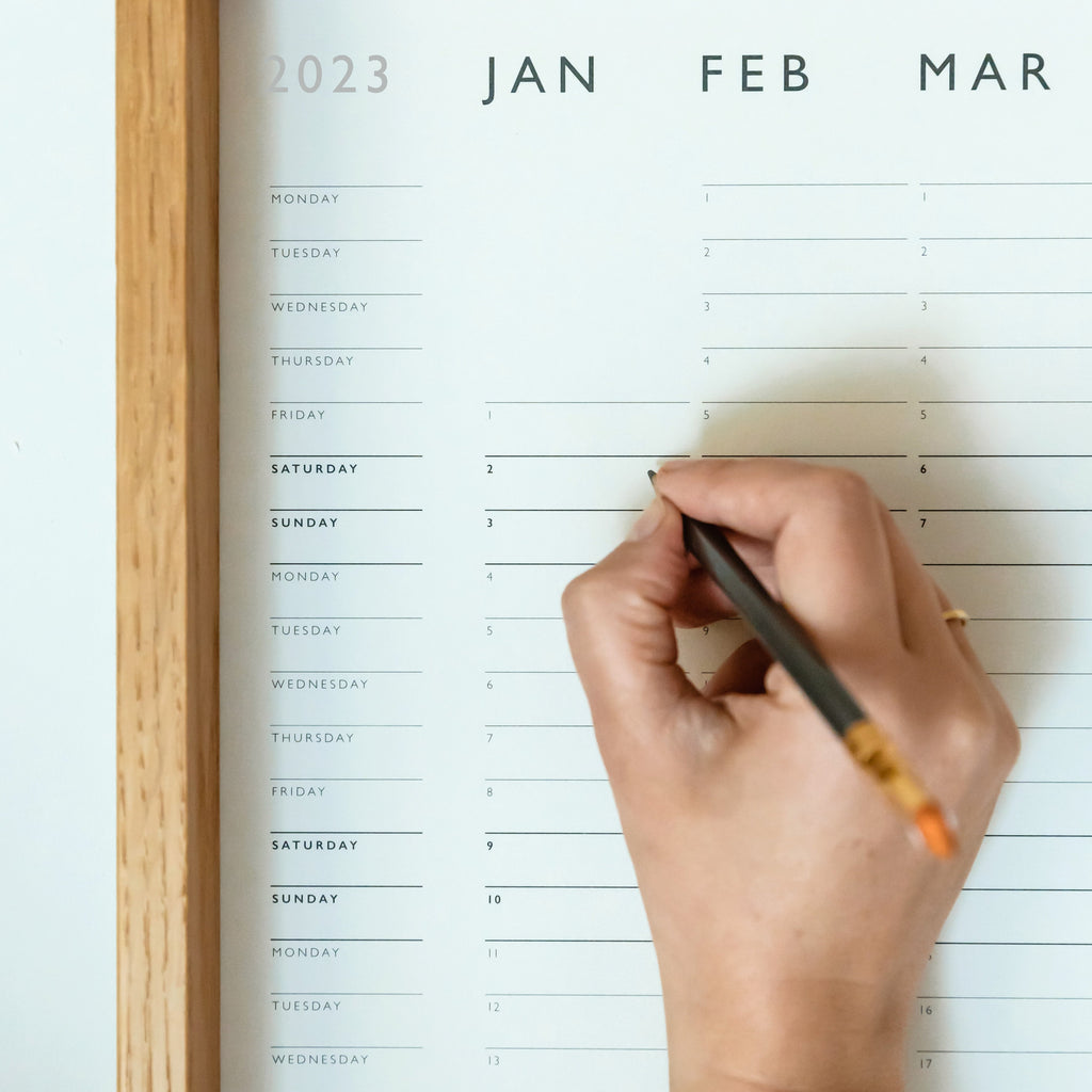 Detail with writing hand and pencil, mark and fold wallplanner colorplan mist 175gsm