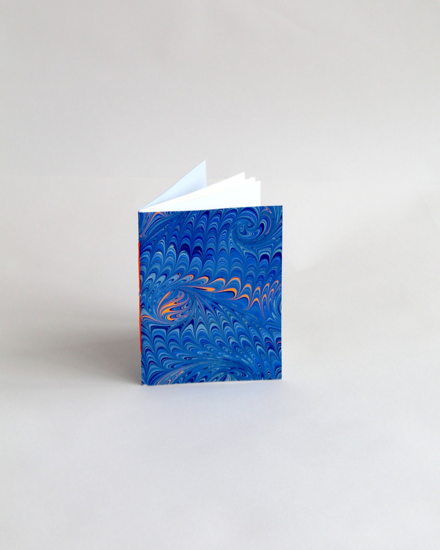 A6 notebook, featuring hand-marbled wave design by Marmor Paperie for Mark+Fold, using the french curl ebru turkish marbling technique