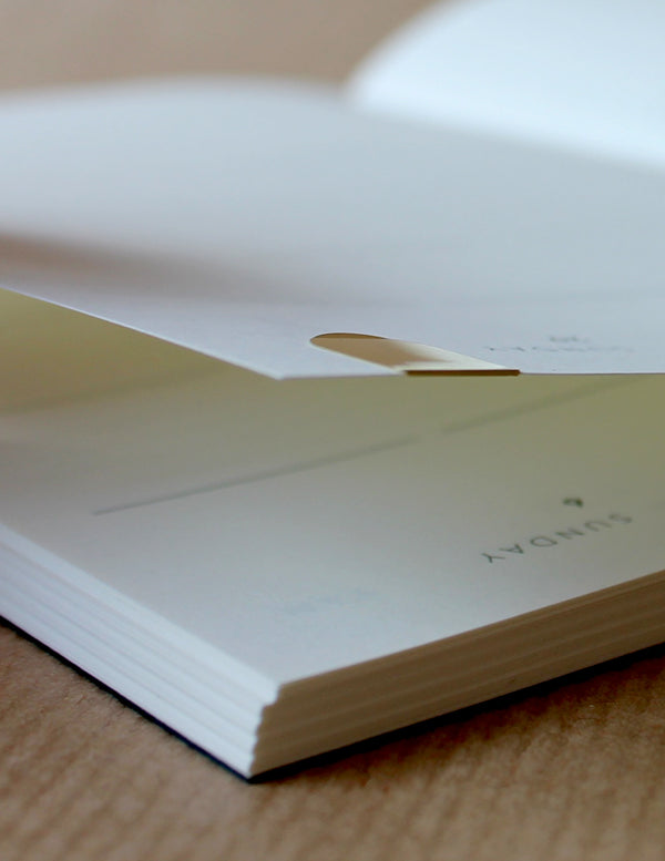 Detail of the Mark+Fold Diary with brass page marker on today's page